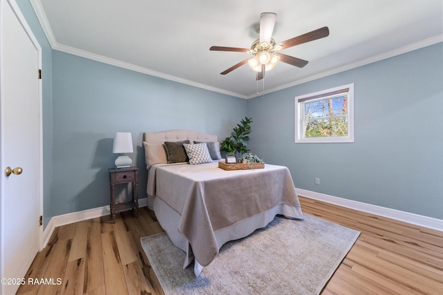 bedroom featuring light hardwood / wood-style floors, ceiling fan, and crown molding