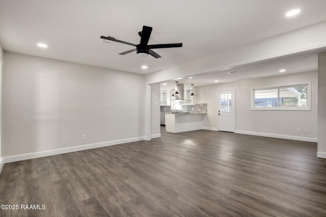 unfurnished living room featuring ceiling fan and dark hardwood / wood-style flooring