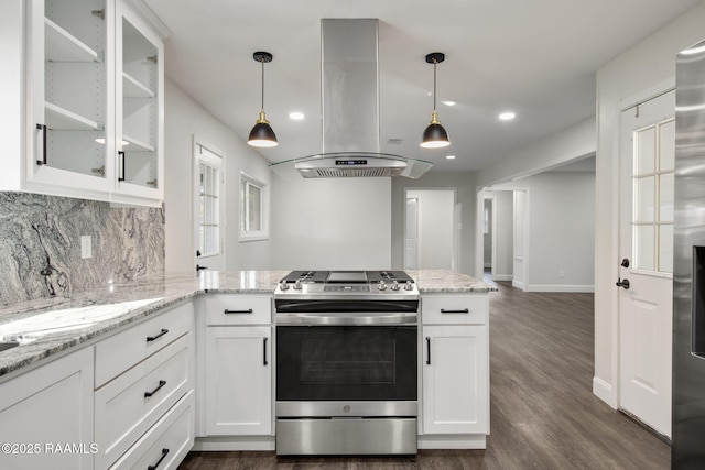 kitchen with white cabinets, stainless steel range oven, light stone countertops, and island exhaust hood