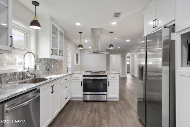 kitchen featuring island exhaust hood, white cabinetry, hanging light fixtures, and stainless steel appliances