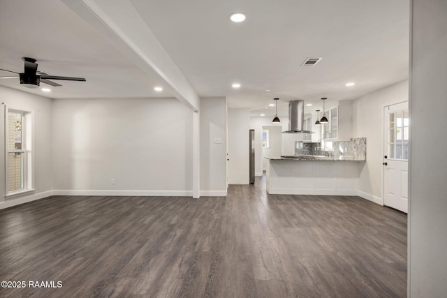 unfurnished living room featuring dark hardwood / wood-style flooring and ceiling fan