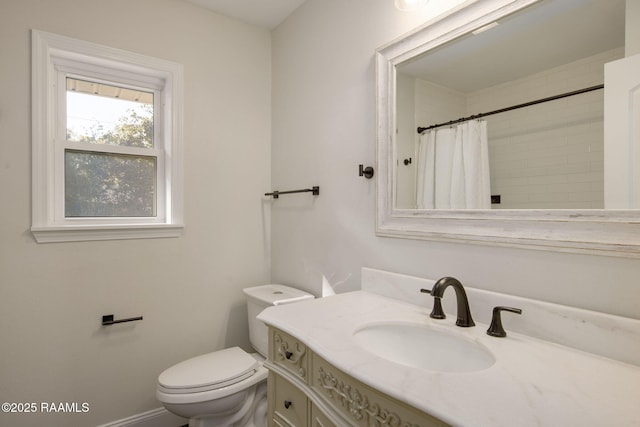 bathroom with curtained shower, vanity, and toilet