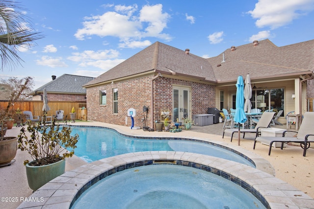 view of pool with an in ground hot tub, a patio, and french doors