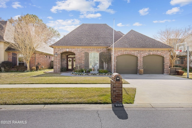 view of front of house with a garage, a front yard, and central AC unit