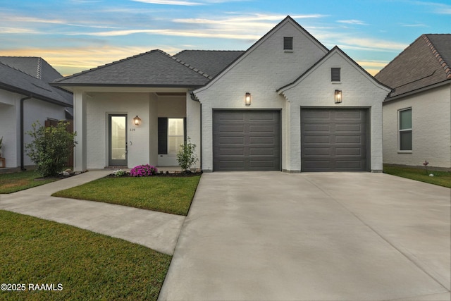 french country home featuring a garage and a lawn