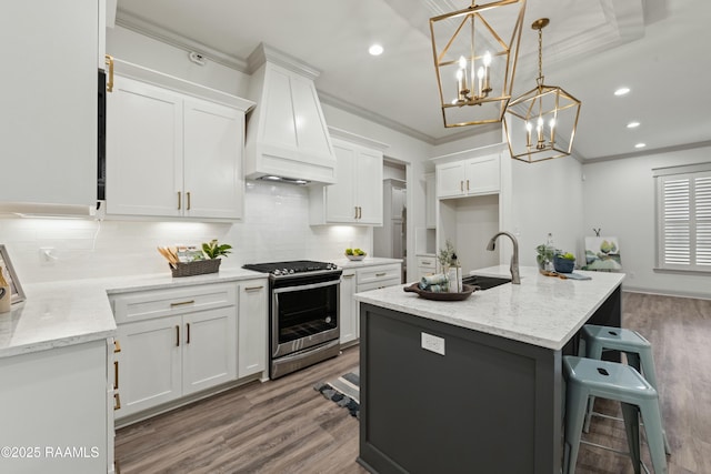 kitchen with white cabinets, decorative light fixtures, stainless steel range oven, and premium range hood