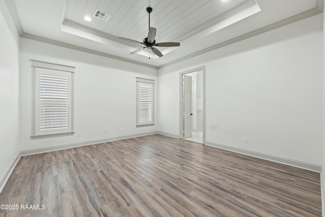 unfurnished room with hardwood / wood-style floors, ceiling fan, a raised ceiling, and crown molding