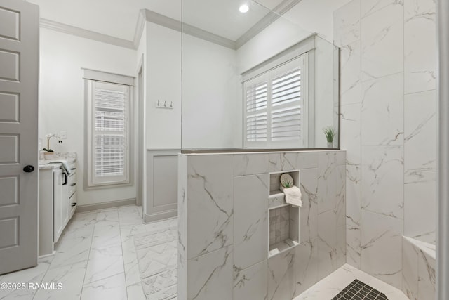 bathroom with vanity, ornamental molding, and tiled shower