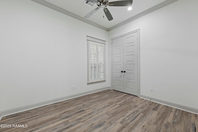 unfurnished bedroom featuring a closet, ceiling fan, crown molding, and hardwood / wood-style flooring