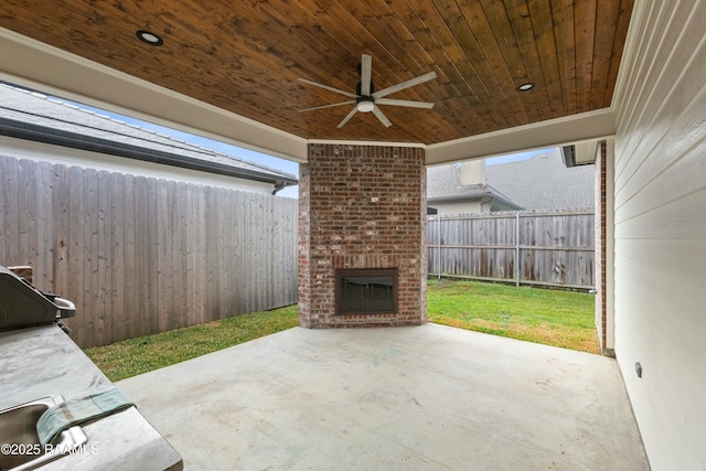 view of patio with an outdoor brick fireplace and ceiling fan