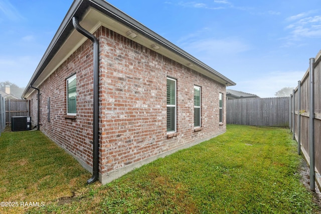 view of property exterior with central AC and a lawn