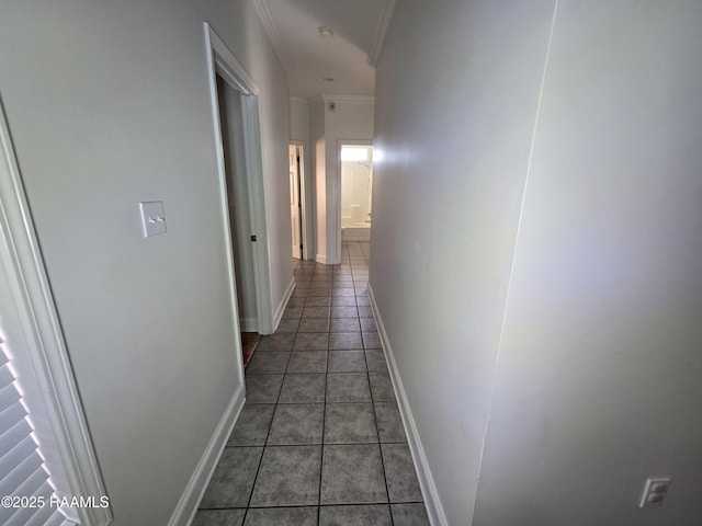 hall featuring dark tile patterned floors and ornamental molding