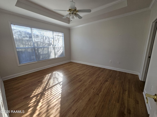 spare room featuring a tray ceiling, dark hardwood / wood-style floors, crown molding, and ceiling fan