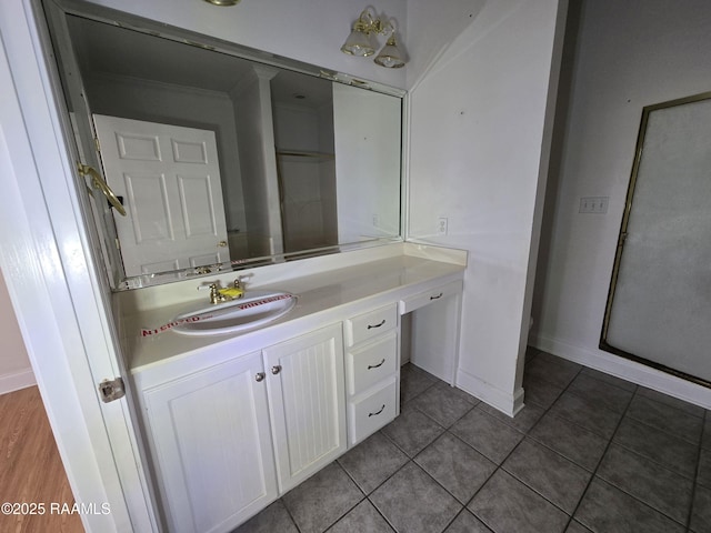 bathroom with tile patterned flooring, vanity, and walk in shower