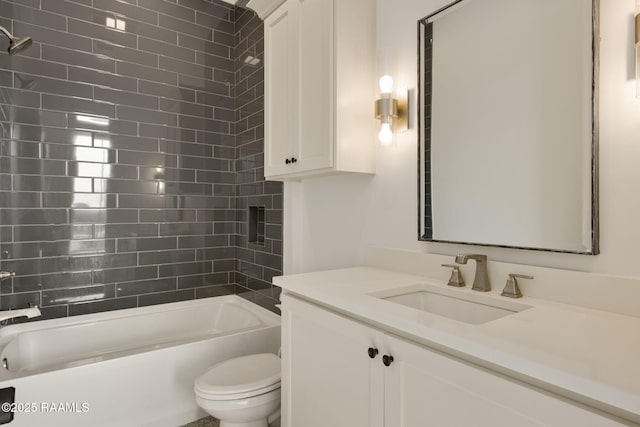 full bathroom featuring tiled shower / bath combo, toilet, and vanity