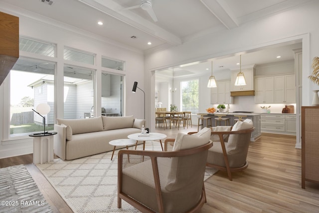 living room with beamed ceiling, ceiling fan, ornamental molding, and light hardwood / wood-style flooring