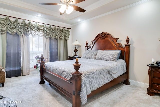 carpeted bedroom with ceiling fan, crown molding, and a tray ceiling