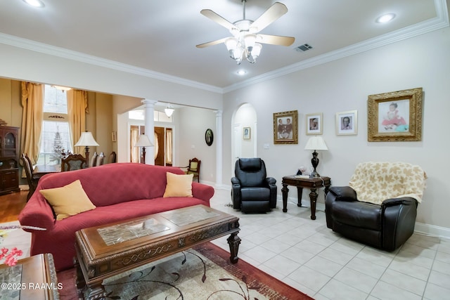 living room featuring light tile patterned floors, ornate columns, ceiling fan, and ornamental molding