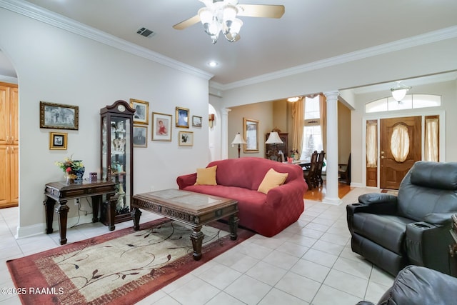 living room featuring ornate columns, crown molding, light tile patterned floors, and ceiling fan