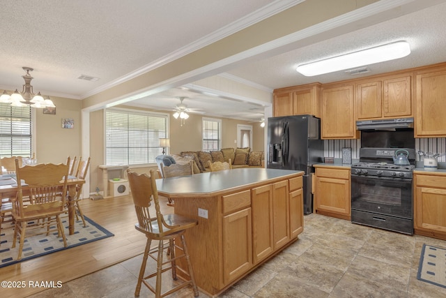 kitchen featuring black appliances, a center island, crown molding, and hanging light fixtures