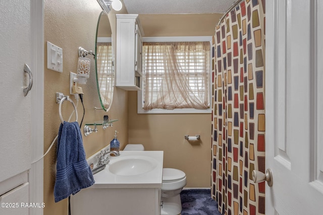 bathroom featuring a textured ceiling, vanity, toilet, and a shower with curtain