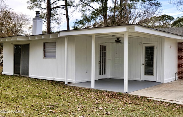 rear view of house featuring ceiling fan, a yard, and a patio area