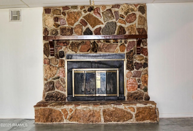 details featuring concrete flooring and a stone fireplace