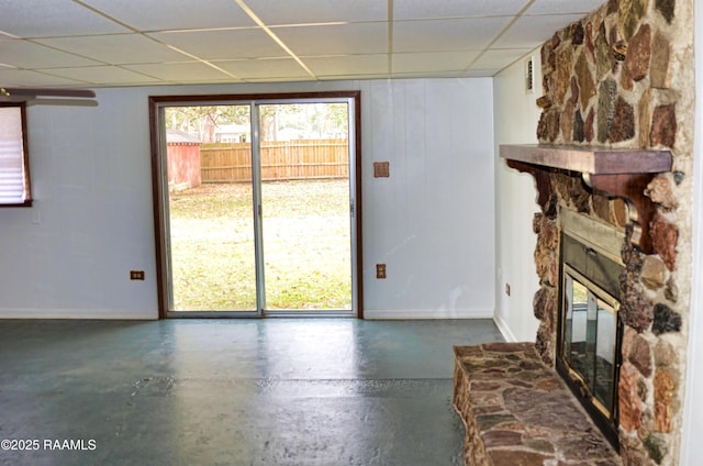 unfurnished living room with a drop ceiling and a fireplace