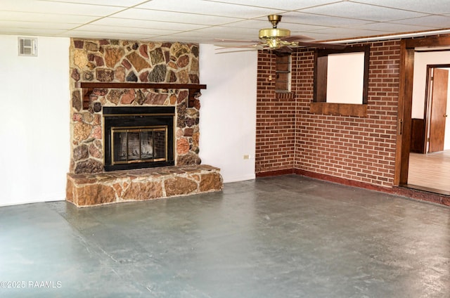 unfurnished living room with a fireplace, ceiling fan, and a paneled ceiling