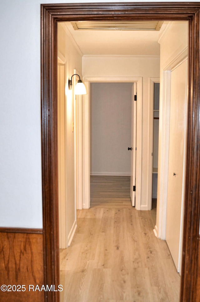 hallway featuring crown molding and light wood-type flooring