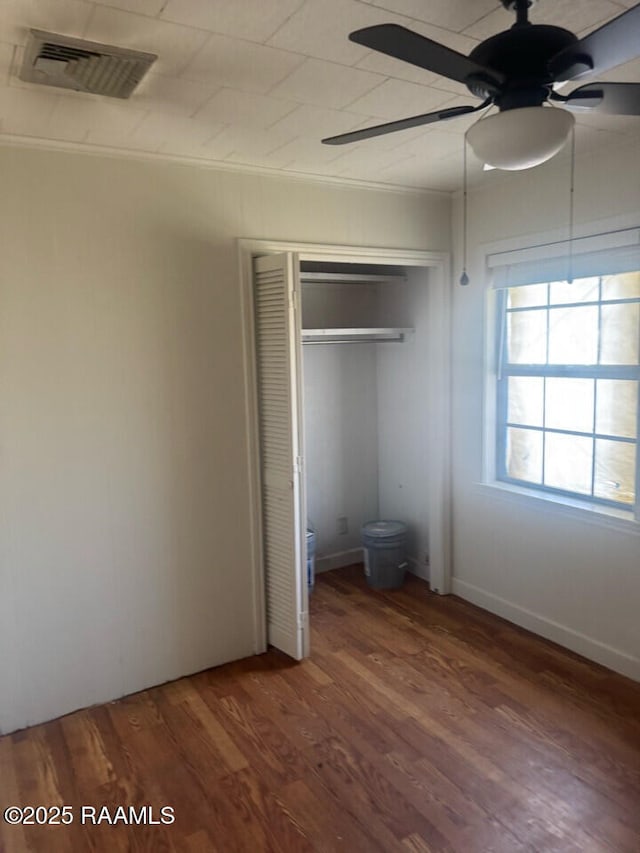 unfurnished bedroom with ceiling fan, dark hardwood / wood-style flooring, and a closet