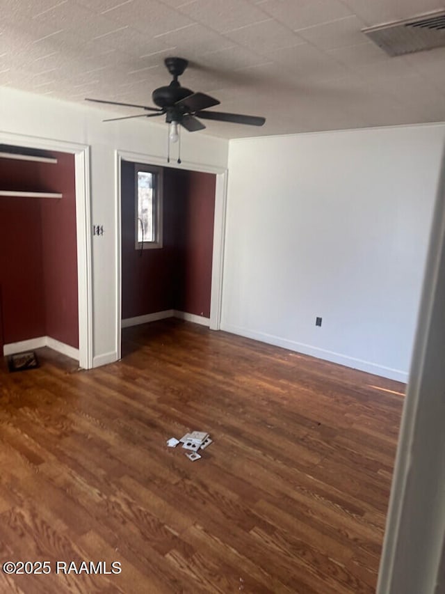 unfurnished bedroom featuring ceiling fan and dark hardwood / wood-style flooring