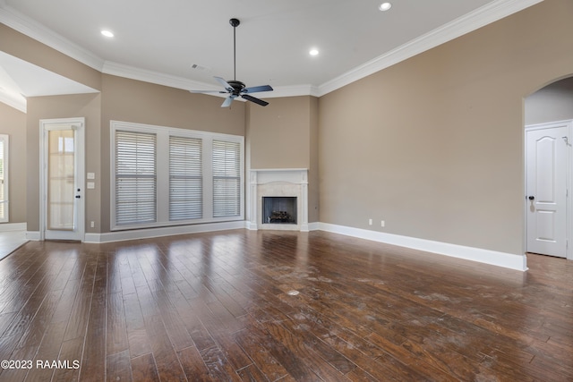 unfurnished living room featuring a fireplace, ceiling fan, ornamental molding, and dark wood-type flooring