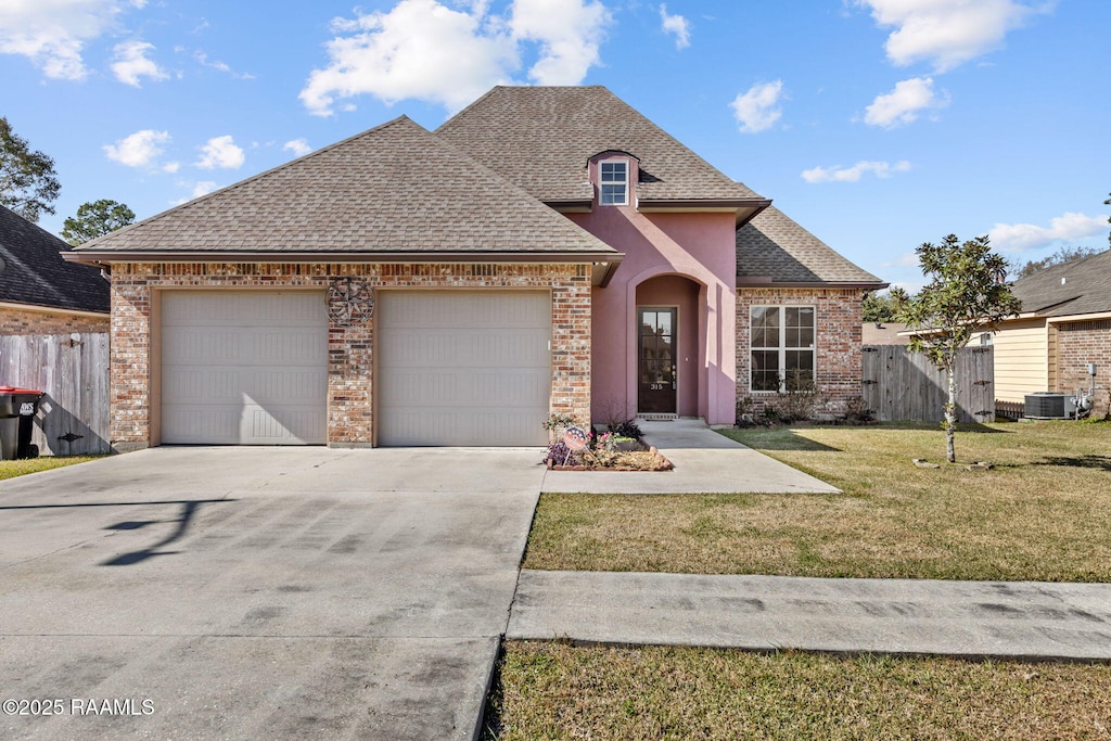 315 Begnaud Dr, Lafayette, LA 70501 - view of front facade featuring central AC, a garage, and a front lawn