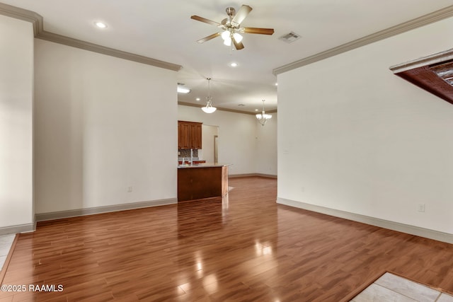 315 Begnaud Dr, Lafayette, LA 70501 - unfurnished living room featuring ceiling fan with notable chandelier, light hardwood / wood-style floors, and crown molding