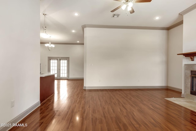 315 Begnaud Dr, Lafayette, LA 70501 - unfurnished living room with ceiling fan with notable chandelier, crown molding, dark wood-type flooring, and a tiled fireplace