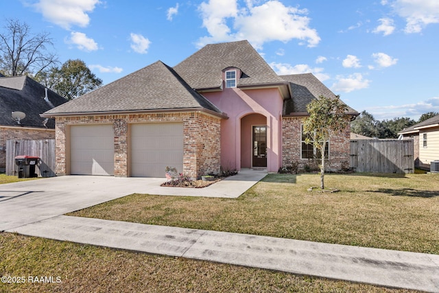 315 Begnaud Dr, Lafayette, LA 70501 - french country style house featuring a garage, a front lawn, and central AC unit