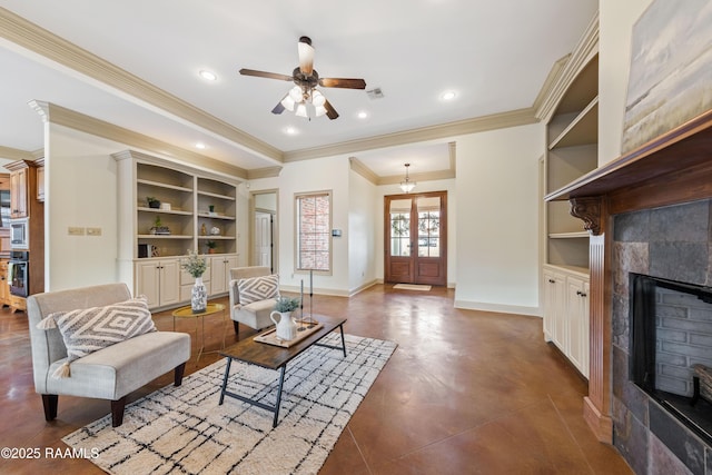 living room with a tile fireplace, french doors, crown molding, ceiling fan, and built in features