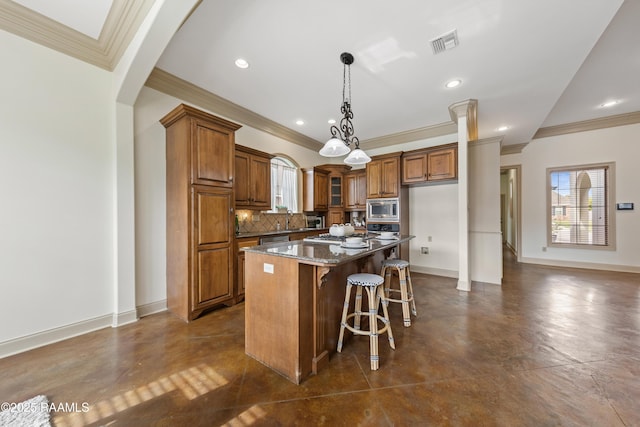 kitchen featuring a breakfast bar area, decorative backsplash, dark stone countertops, a kitchen island, and stainless steel appliances