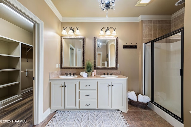 bathroom with crown molding, vanity, and a shower with shower door