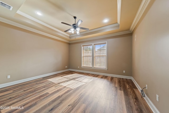 unfurnished room featuring a tray ceiling, dark hardwood / wood-style floors, ornamental molding, and ceiling fan