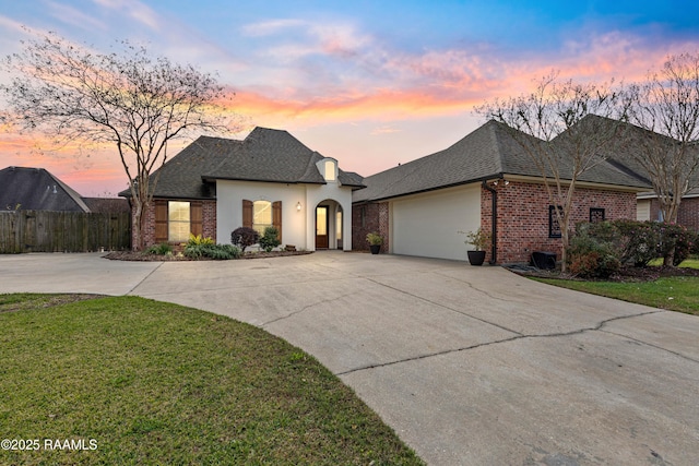 french provincial home with a garage and a yard