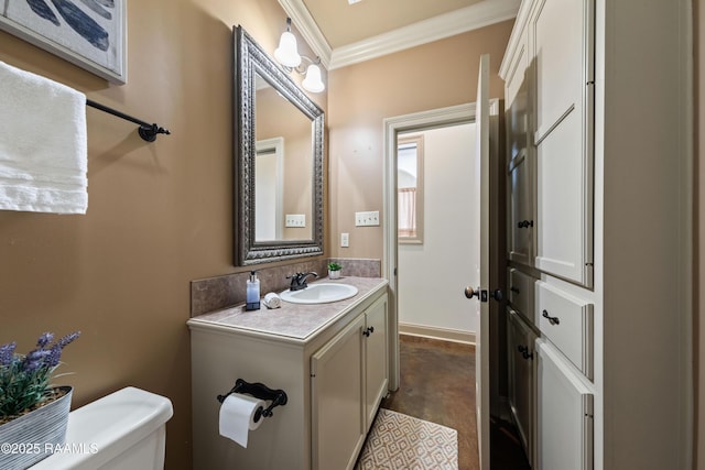 bathroom with crown molding, vanity, and toilet