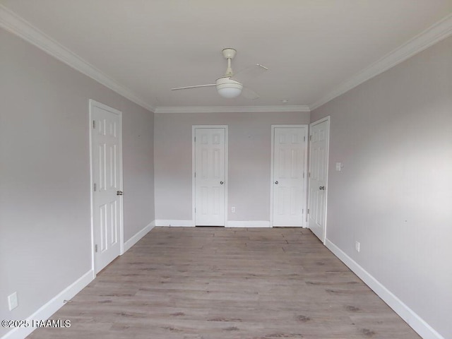 unfurnished bedroom with two closets, light hardwood / wood-style flooring, ceiling fan, and ornamental molding