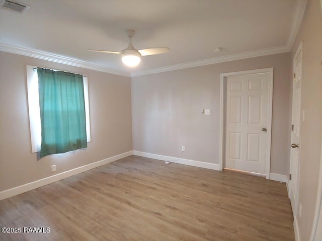 spare room with a ceiling fan, baseboards, visible vents, light wood-style flooring, and ornamental molding