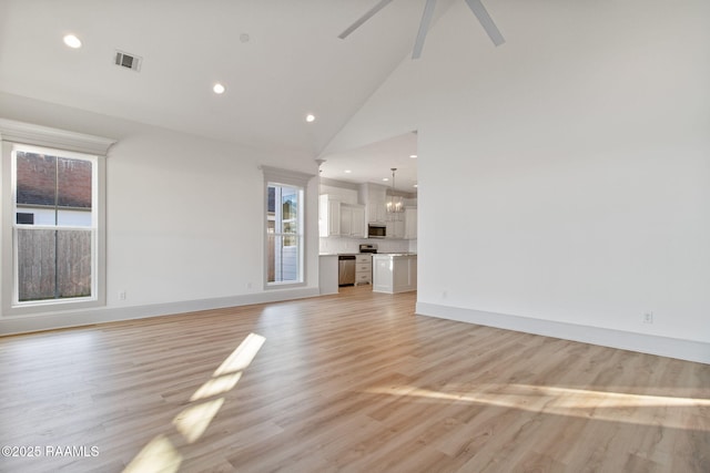 unfurnished living room featuring light wood-type flooring, high vaulted ceiling, and ceiling fan