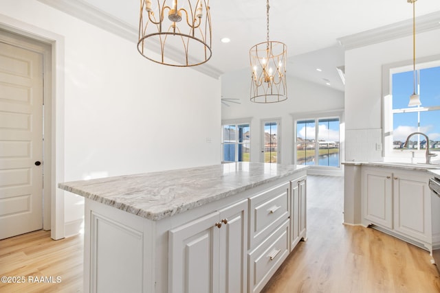 kitchen featuring white cabinetry, a center island, ceiling fan, sink, and light hardwood / wood-style floors