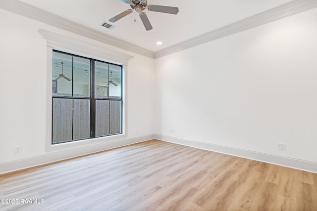 spare room with crown molding, a wealth of natural light, and light hardwood / wood-style flooring