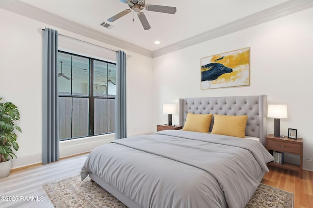 bedroom with multiple windows, light hardwood / wood-style flooring, ceiling fan, and ornamental molding