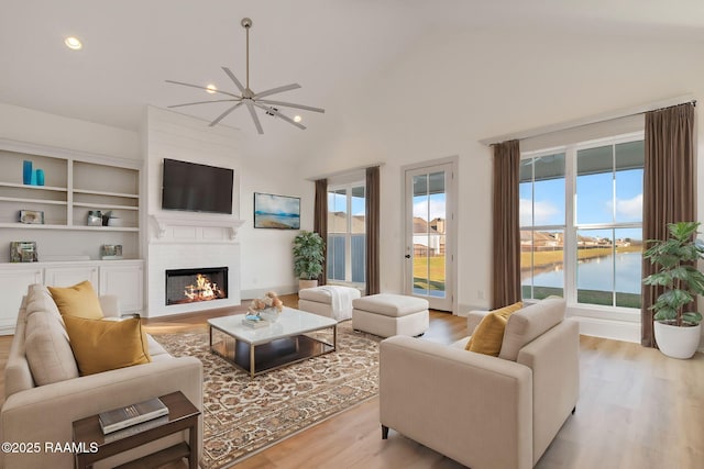 living room featuring plenty of natural light, ceiling fan, light hardwood / wood-style floors, and lofted ceiling